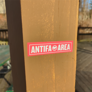 "Antifa Area" sticker on a wooden post