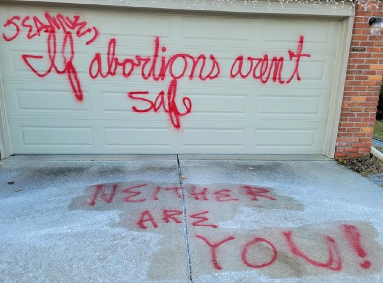 Jeanne Vanegmond's garage door is spraypainted to read "Jeanne, If abortions aren't safe neither are you!"